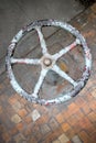 Old rusty valve wheel painted blue red with peeling selective focus with extension device over out of focus background Royalty Free Stock Photo