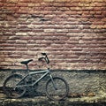 Old rusty vintage bicycle leaning against a brick wall Royalty Free Stock Photo