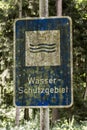 Old rusty vintage forgotten german sign in forest translation wasser schutzgebiet means water reserve Royalty Free Stock Photo