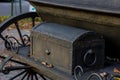 Old rusty vintage large black metal chest in the street.