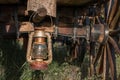 Old rusty vintage oil lantern lamp hanging on a log