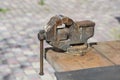 Old rusty vise for metal products on wooden table, outdoors Royalty Free Stock Photo