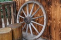 Old rusty wagon wheel leaning on a wooden wall Royalty Free Stock Photo