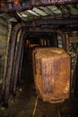 Old rusty wagons in abandoned mine tunnel with wooden timbering