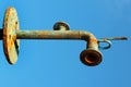 Old rusty water pipe on blue sky background Royalty Free Stock Photo