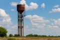 Old rusty water tower in green field Royalty Free Stock Photo