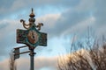 Old, rusty, weathered, ornate clock and wind gauge standing against cloudy sky