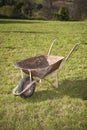 Old rusty wheelbarrow cart in the garden Royalty Free Stock Photo