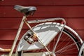 Old rusty white bike against a red wall.. Royalty Free Stock Photo