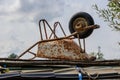 Old rusty white metal wheelbarrow upside down abandoned on wooden planks Royalty Free Stock Photo