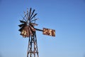 Old rusty wind mill or wind pump opposite clear blue sky Royalty Free Stock Photo