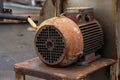 An old rusty working engine stands on a locksmith`s chair. exhaust system engine.