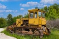 An old rusty yellow crawler bulldozer is standing in the forest Royalty Free Stock Photo