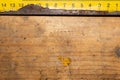 Old rusty yellow ruler with black numbers on a working wooden table. industrial background. carpentry workbench Royalty Free Stock Photo