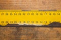 Old rusty yellow ruler with black numbers on a working wooden table. industrial background. carpentry workbench Royalty Free Stock Photo