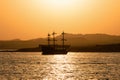 old sailboat sailing against the background of a yellow sunset. Beautiful summer landscape. A yacht in the style of an old Royalty Free Stock Photo