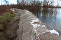 Old sandbags flood protection with completely torn sandbags on top