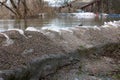 Old sandbags flood protection holding back river