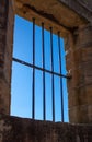 Old sandstone gaol cell jail cell with one missing window bar against blue sky Royalty Free Stock Photo