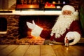 Old Santa Claus sitting in old throne chair in home interior and wooden table top with free space for your decoration. Royalty Free Stock Photo