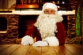 Old Santa Claus sitting in old throne chair in home interior and wooden table top with free space for your decoration. Royalty Free Stock Photo