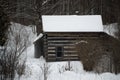 Old sawn log cabin in the snow in winter landscape