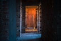 Old, scary, abandoned house interior. Wooden door at the end of scary concrete corridor. Architecture structure Royalty Free Stock Photo