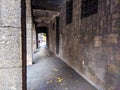 Old and scary looking exterior hallway corridor next to an old building facade with dark and abandoned feeling to it Royalty Free Stock Photo