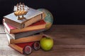 The old school books, textbooks and school supplies lie on wooden table. Globe in the background. Royalty Free Stock Photo