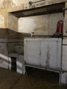 Old school hall sink rustic wall peeled painting, iron pieces, wooden cabinets, fire extinguishers, dramatic natural light Royalty Free Stock Photo