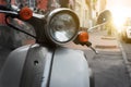 An old-school scooter stands parked on a European city street Royalty Free Stock Photo