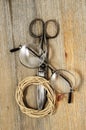 old scissors, glasses and hank of packthread on wooden background