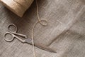 Old scissors and skein jute twine on a burlap, rustic