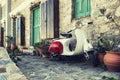 Old scooter parked by the wall in the empty street of Karpathos, Greece. Royalty Free Stock Photo