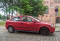 Old scrap car red Opel Astra hatchback parked