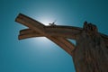 Old sculpture with a bright sun shining behind it in a clear blue sky in Esztergom, Hungary