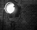 Old searchlight against brick wall close-up. Black-white photo