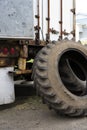 Old semi truck tires without rims stand near an old rusty trailer Royalty Free Stock Photo