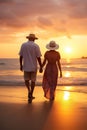 old senior couple walking by sea beach at sunset, older romantic man and woman walk by ocean shore at summer sunrise Royalty Free Stock Photo