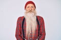 Old senior man with grey hair and long beard wearing hipster look with wool cap with a happy and cool smile on face Royalty Free Stock Photo