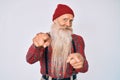 Old senior man with grey hair and long beard wearing hipster look with wool cap pointing fingers to camera with happy and funny Royalty Free Stock Photo