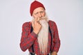 Old senior man with grey hair and long beard wearing hipster look with wool cap pointing to the eye watching you gesture, Royalty Free Stock Photo