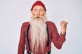 Old senior man with grey hair and long beard wearing hipster look with wool cap surprised pointing with hand finger to the side, Royalty Free Stock Photo