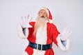 Old senior man with grey hair and long beard wearing santa claus costume with suspenders afraid and terrified with fear expression Royalty Free Stock Photo