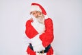 Old senior man with grey hair and long beard wearing santa claus costume with suspenders thinking looking tired and bored with Royalty Free Stock Photo