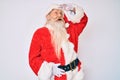 Old senior man with grey hair and long beard wearing santa claus costume with suspenders very happy and smiling looking far away Royalty Free Stock Photo