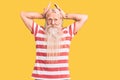 Old senior man with grey hair and long beard wearing striped tshirt doing bunny ears gesture with hands palms looking cynical and Royalty Free Stock Photo