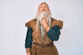 Old senior man with grey hair and long beard wearing viking traditional costume thinking concentrated about doubt with finger on Royalty Free Stock Photo