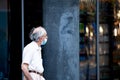 Old senior man wearing a respiratory face mask walking in a street of Belgrade