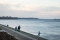 Old senior man and woman, couple, wearing a facemask, waking in front of danube river in winter of Belgrade during  coronavirus Royalty Free Stock Photo